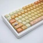 Vibrant Orange Garden PBT dye-sub keycaps set. Multi-angle views capture the botanical theme with vibrant orange foliage, a natural aesthetic.