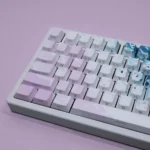 Dreamy Pink Beach PBT keycaps set showcasing a close-up angle of the serene coastal design, featuring soft pinks and warm neutrals. Durable PBT material.