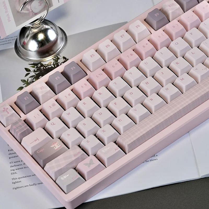 Pink PBT Keycap Set. Durable PBT, serene pastel pink, and 'Gentle World' graphics in Cherry profile create a calming desktop.