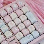 Vibrant pink Rock Cat MOA Keycap Set from a distinct angle, showcasing playful cartoon designs and unique rebellious charm.