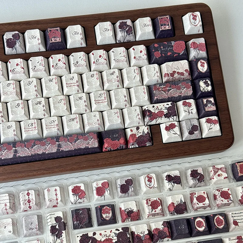 The Red & Black Rose PBT Dye-Sub Keycap Set displayed from multiple angles, highlighting its dramatic gothic floral patterns and durable quality.