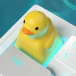 A whimsical, handcrafted resin little yellow duck keycap captured from a unique angle, showcasing its intricate details and playful charm for mechanical keyboard.