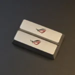 A pair of premium silver Republic of Gamers: ROG Logo Split Space Key Keycaps, showcasing a bold, sculpted design perfect for an aggressive gaming aesthetic.