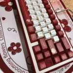 Close-up of premium PBT dye-sub rose keycaps set, showcasing intricate red floral designs from an artistic angle, highlighting the captivating rose garden.