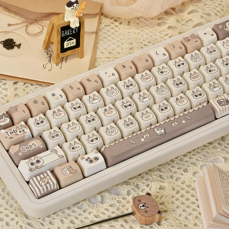Charming Siamese Cat PBT Keycap Set, showcasing whimsical stylized Siamese cat designs in warm cream and brown tones. Artistic keycaps perfect for pet lovers.