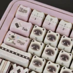 Close-up of the adorable pink Siamese cat PBT keycap set, highlighting its whimsical illustration and vibrant colors from a unique angle, perfect for customization.