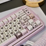 Adorable pink Siamese cat PBT keycap set, displayed from various angles. Whimsical, vibrant illustration on durable PBT for playful keyboard charm.
