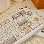Close-up of a charming Siamese cat PBT keycap set, revealing its whimsical stylized design in warm cream and brown tones. A delightful piece from the Azukisan.