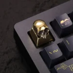 Handcrafted pure alloy skull artisan keycap for mechanical keyboards, detailed from multiple angles. Showcases intricate gothic design and raw metallic design.