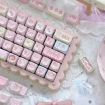 The whimsical Strawberry Cake Bear PBT MOA keycap set arranged on a keyboard, emphasizing the cute strawberry and bear designs in soft pastel shades.