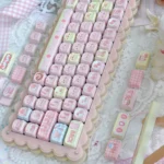Gallery of the Whimsical Strawberry Cake Bear PBT MOA Keycap Set, showing adorable bear and strawberry cake motifs from various angles in vibrant pastel design.