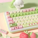 An artistic product gallery view of the Strawberry Milk Rabbit PBT Keycap Set, featuring a charming array of pastel keycaps with whimsical design.