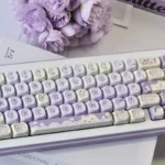 Adorable Taro Paste Kitten PBT dye-sub MOA keycaps set in soft pastel purple and white, showcasing various playful kitten and taro paste motifs from multiple angles.
