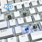 A collection of handcrafted translucent Valorant Kay/O skill keycaps from various angles, showcasing their vibrant resin art and glowing energy.