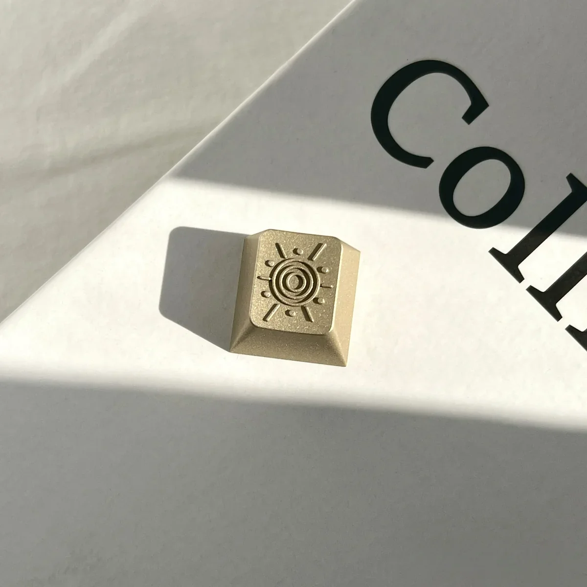 Radiant Premium CNC Sunburst Vintage Brass Keycap. Elegant, intricate sunburst pattern with a timeless, vintage-industrial aesthetic.