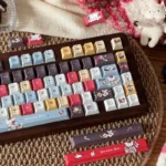 Multiple angles of the distinctive Wacky Doll artisan keycap set, showcasing its quirky character and vibrant PBT dye-sub artistic design.