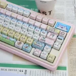 A collection of whimsical characters keycaps set in various angles, showcasing the cute PBT dye-sub design with three playful cat heads. Perfect for a unique keyboard.