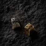 Close-up view of the intricate Pure Brass Yu-Gi-Oh! Cross artisan keycap, highlighting its gleaming metallic finish and detailed sculpting from a side view.