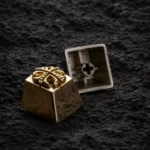 Pure brass Yu-Gi-Oh! Cross artisan keycap, intricately sculpted with a gleaming metallic finish, captured from an appealing angle to highlight its premium setup.