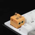 Whimsical handcrafted cat in box artisan resin keycap. Intricate miniature cat within charming resin casing. Artistic keyboard detail.