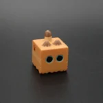 Whimsical handcrafted resin keycap featuring an intricately sculpted miniature cat inside box, captured from a charming side angle.
