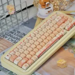 Playful baking cat artisan keycap set, a PBT MOA accent, shown from a unique angle, highlighting its adorable pastel colors and soft bread motifs.