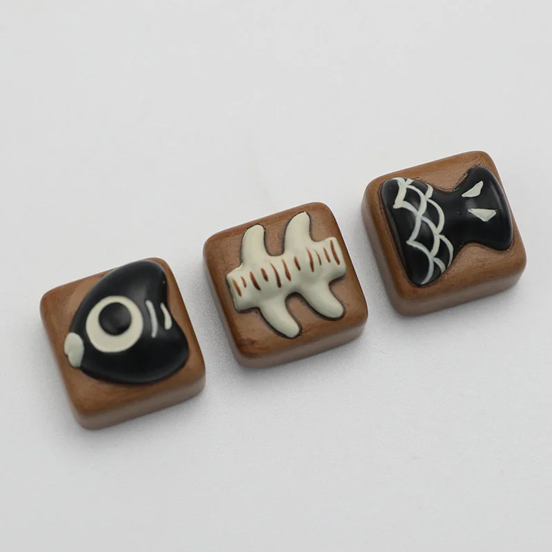 Close-up of a whimsical handcrafted resin fish bone artisan keycap, showcasing its unique charm and vibrant details from multiple artistic angles.