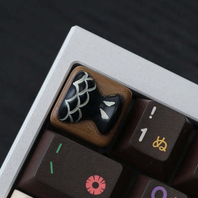 Close-up of a whimsical handcrafted resin fish bone artisan keycap, showcasing its unique charm and vibrant aquatic details from multiple angles.