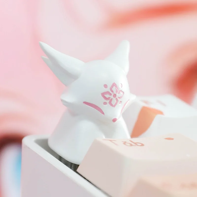 Handcrafted artisan resin keycap featuring a mythical fox and delicate peach blossoms, showcasing unique translucent detail from a different angle.