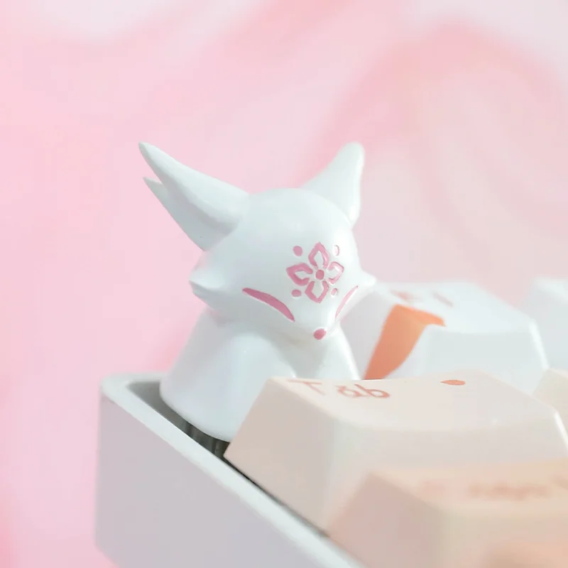 Stunning handcrafted artisan keycap showcasing a mythical fox amidst delicate peach blossoms, encased in luminous translucent resin.
