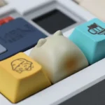 Detailed artisan resin keycaps featuring the charming Wangzai Cat and playful Takoyaki, presented from multiple angles to highlight unique craftsmanship.