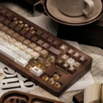 Gallery views of the Brew-tiful coffee keycap set, highlighting unique PBT dye-sub keycaps with warm cat accents and transparent keys.