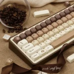 Playful Brew-tiful coffee keycap set for mechanical keyboards. Warm PBT dye-sub keycaps feature charming cat accents and modern transparent details.