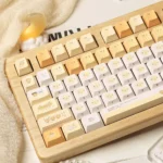 A playful gallery of unique Burnt Toast PBT dye-sublimated keycaps set, showcasing various angles of their warm toasted design with crispy accent.