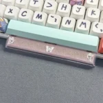 Close-up of a handcrafted translucent butterfly artisan space key keycap, showcasing its ethereal glow and delicate resin details on a mechanical keyboard.
