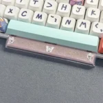 A close-up view of a handcrafted translucent butterfly artisan space key keycap, showcasing its delicate resin details and ethereal glow from various angle.