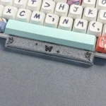 Ethereal handcrafted black translucent butterfly artisan space key keycap, glowing delicately in resin for a unique keyboard aesthetic.