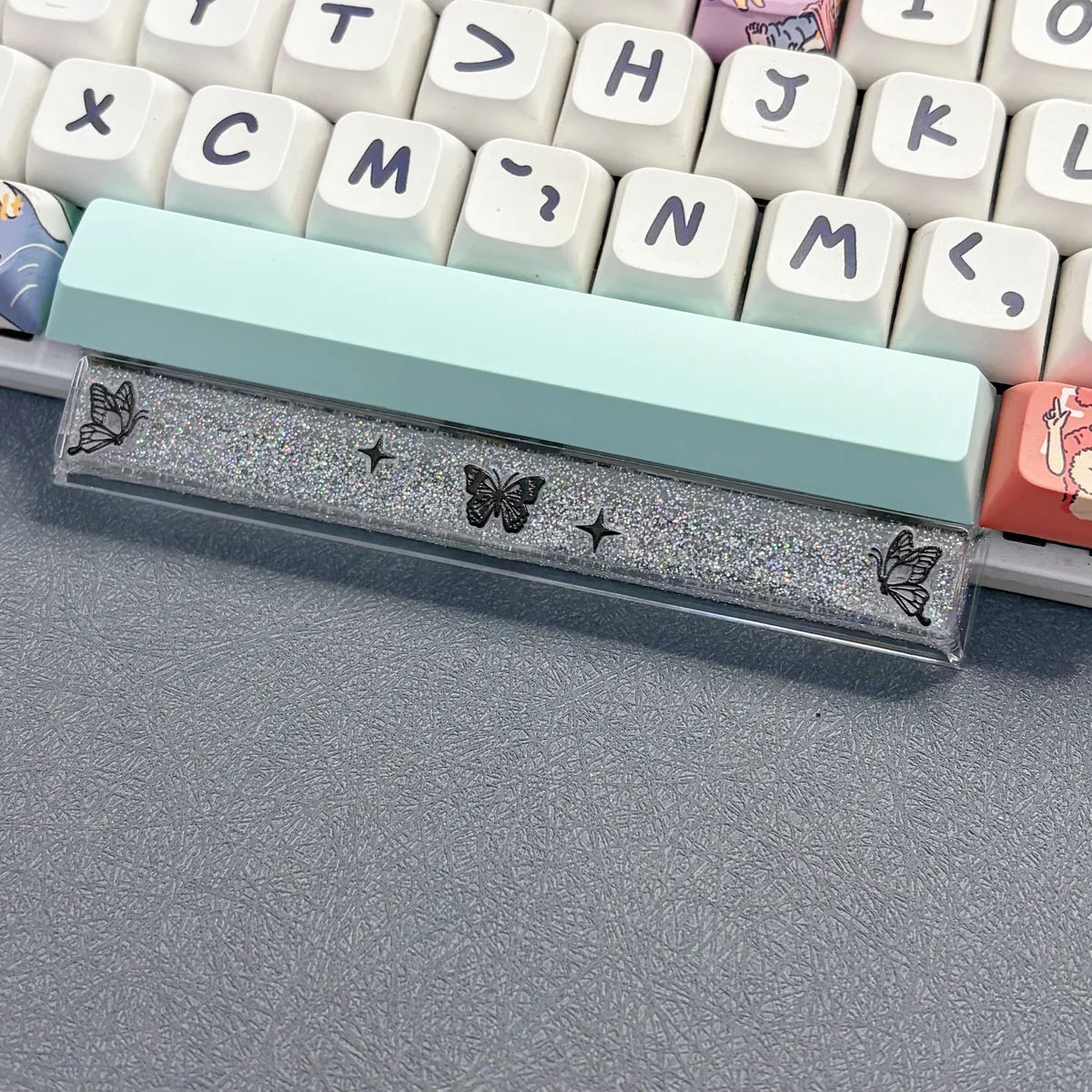 Ethereal handcrafted black translucent butterfly artisan space key keycap, glowing delicately in resin for a unique keyboard aesthetic.