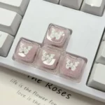 Ethereal Pink Butterfly Resin Keycap, shown from different angles, highlights its handcrafted translucent resin, shimmering pink glitter, and dedicated design.