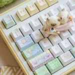 Detailed shot of the Whimsical Cat Fishing PBT Dye-Sub Keycaps Set, highlighting charming cartoon cats on various keys, creating a playful, tranquil desk.
