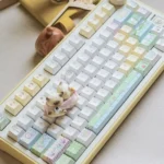 Close-up of charming Cat Fishing PBT Dye-Sub Keycaps set, showcasing playful cartoon cats fishing on serene blue keycaps, adding a whimsical desktop.