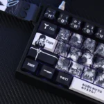 Close-up of the exclusive Kobeni's Charm PBT keycaps set, showcasing vibrant Chainsaw Man anime art from a unique angle.