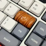Close-up of a handcrafted artisan chocolate keycap, showcasing its rich, smooth resin finish resembling gourmet caramel candy from a unique angle.