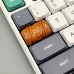 An artisan chocolate keycap, meticulously handcrafted from smooth resin, displaying its rich caramel and dark brown hues from multiple angles.