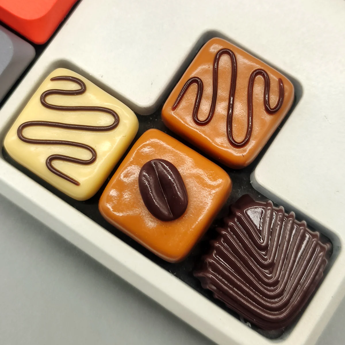 A close-up view of a Caramel Coffee Bean Chocolate Low Shaft Keycap, showcasing its intricate dessert and coffee-inspired patterns from a unique art.