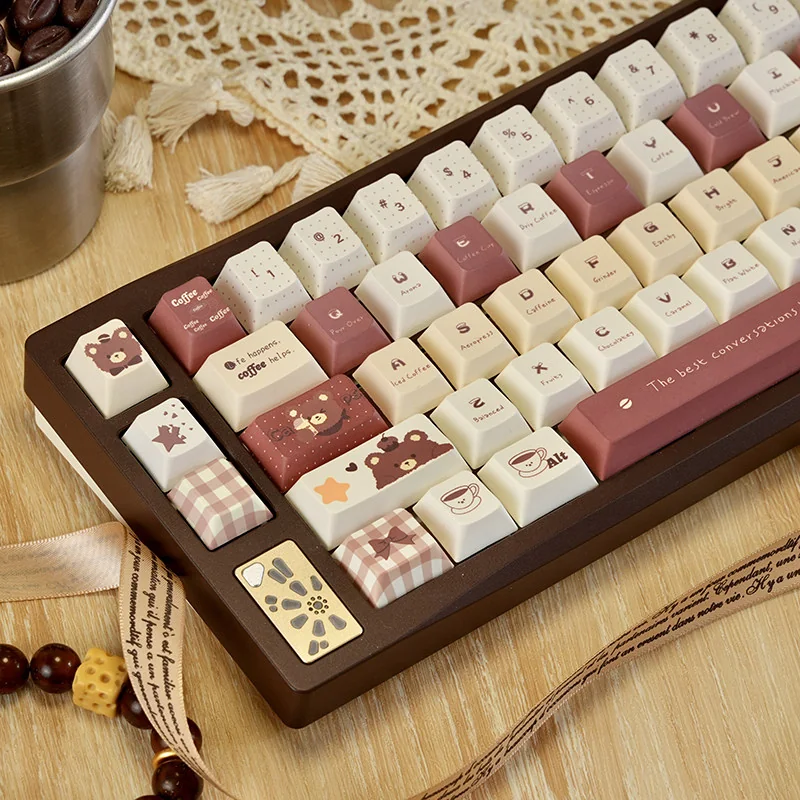 Playful side view of the adorable PBT dye-sub coffee bear keycap set, showcasing its charming cartoon character and warm, earthy tones. A cozy, whimsical design.