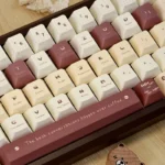 Adorable coffee bear PBT dye-sub keycap set for keyboards, showcasing its charming cartoon design and warm, earthy tones from a playful, detailed perspective view.