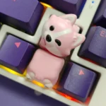 Close-up of an adorable, whimsical Corgi butt keycap in soft pink resin, showcasing its hand-painted details from multiple charming angles.