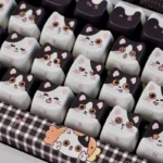 Multiple views of the whimsical Cow Cat Keycap Set, a unique artisan novelty. Its adorable black and white cow-patterned cat head for mechanical keyboard.