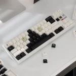 Captivating Cow Cat PBT keycap set, black and white, featuring playful feline designs from various perspectives for an artistic custom keyboard.